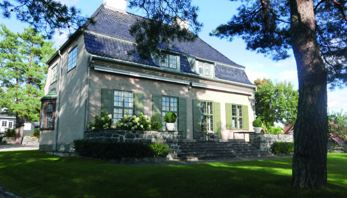 FRANSKINSPIRERT: Husets sydvendte fasade med stor terrasse og gressplen foran, sett fra oppkjørselen. FRANSKINSPIRERT: Husets sydvendte fasade med stor terrasse og gressplen foran, sett fra oppkjørselen.