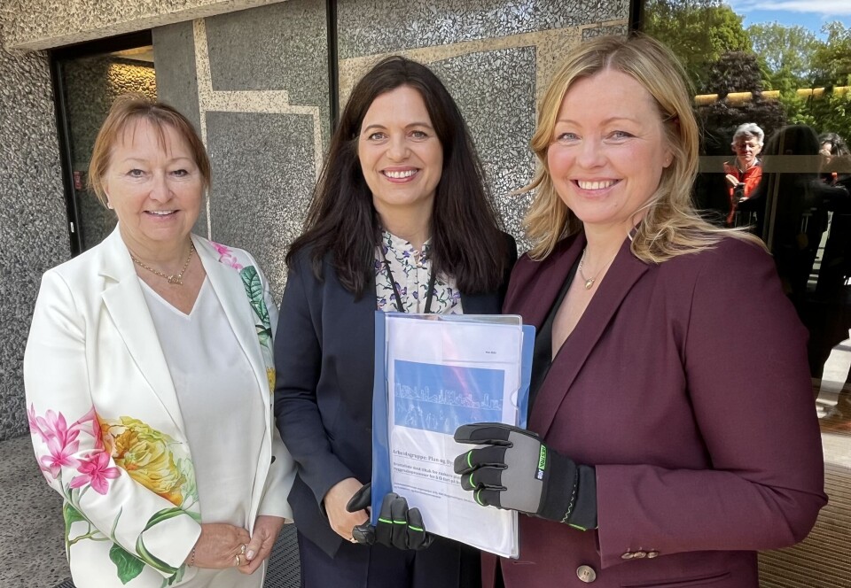 RAPPORTEN OVERLEVERT: Kommunal- og distriktsminister Kjersti Stenseng fikk tildelt arbeidshansker for anledningen. Her sammen med KS-leder Gunn Marit Helgesen og Nina Solli, administrerende direktør i NHO Byggenæringen. Gunn Marit Helgesen, Nina Solli og Kjersti Stenseng. Foto: Glen Widing